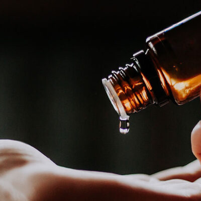 aromatherapie, flesje met etherische, een druppel valt op een hand