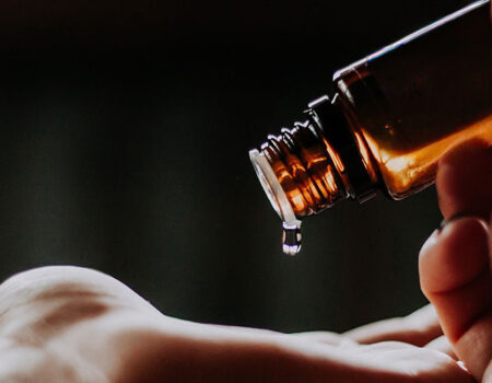 aromatherapie, flesje met etherische, een druppel valt op een hand