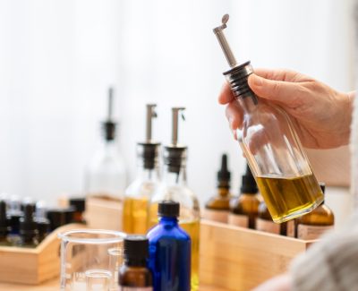 Handen van Caroline Vermeulen met biologische aromatherapieolie voor massage bij kanker"