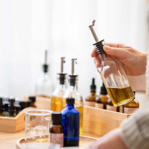 Handen van Caroline Vermeulen met biologische aromatherapieolie voor massage bij kanker"